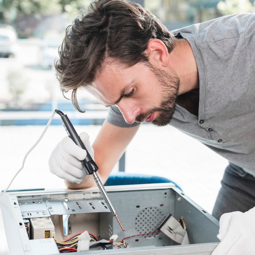 side-view-of-male-technician-repairing-computer-cpu-in-workshop